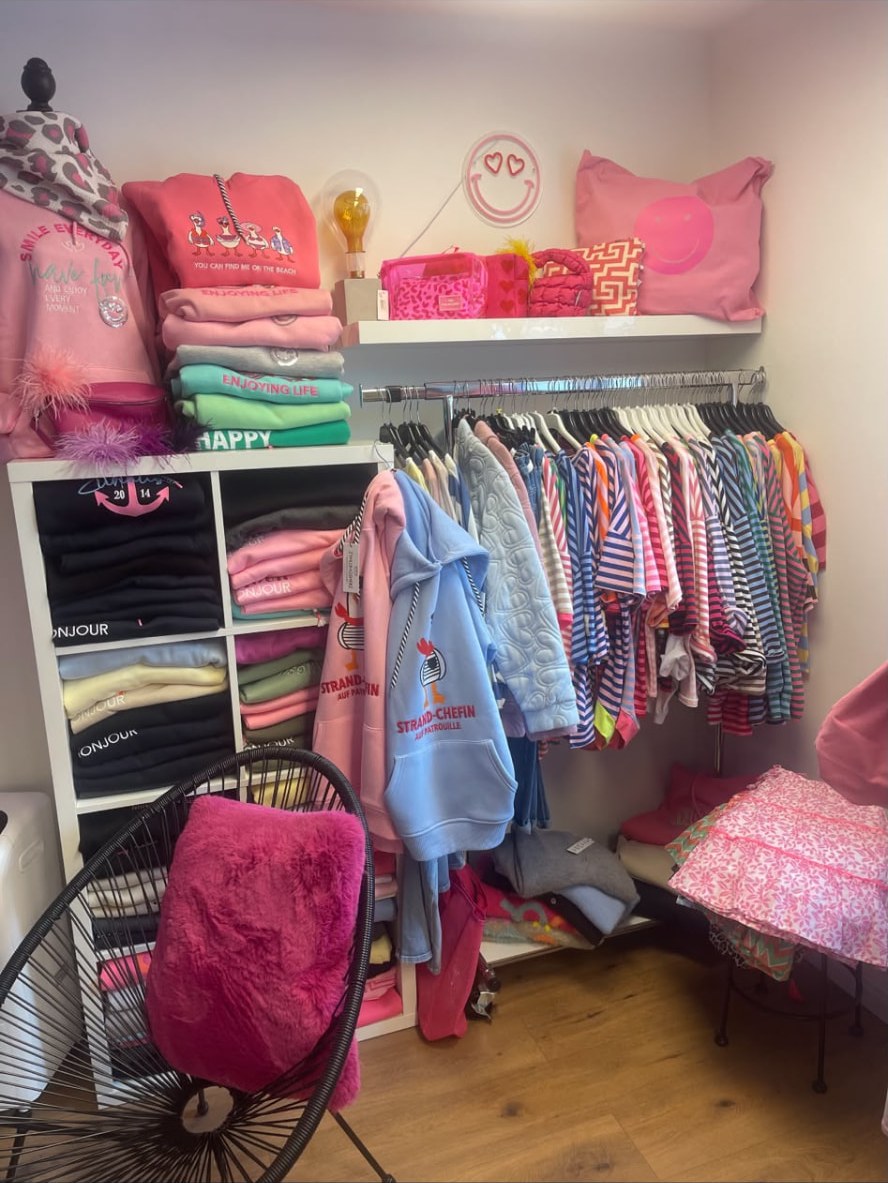 Pinke Ecke mit Kissen, Taschen und Neon-Smiley in der Boutique
